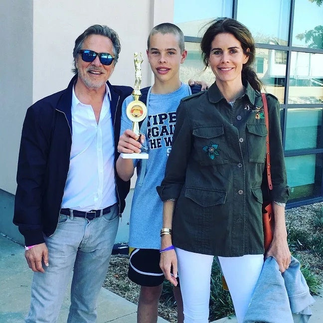 Jasper Breckenridge Johnson holding his trophy and posing with his parents after his basketball match.