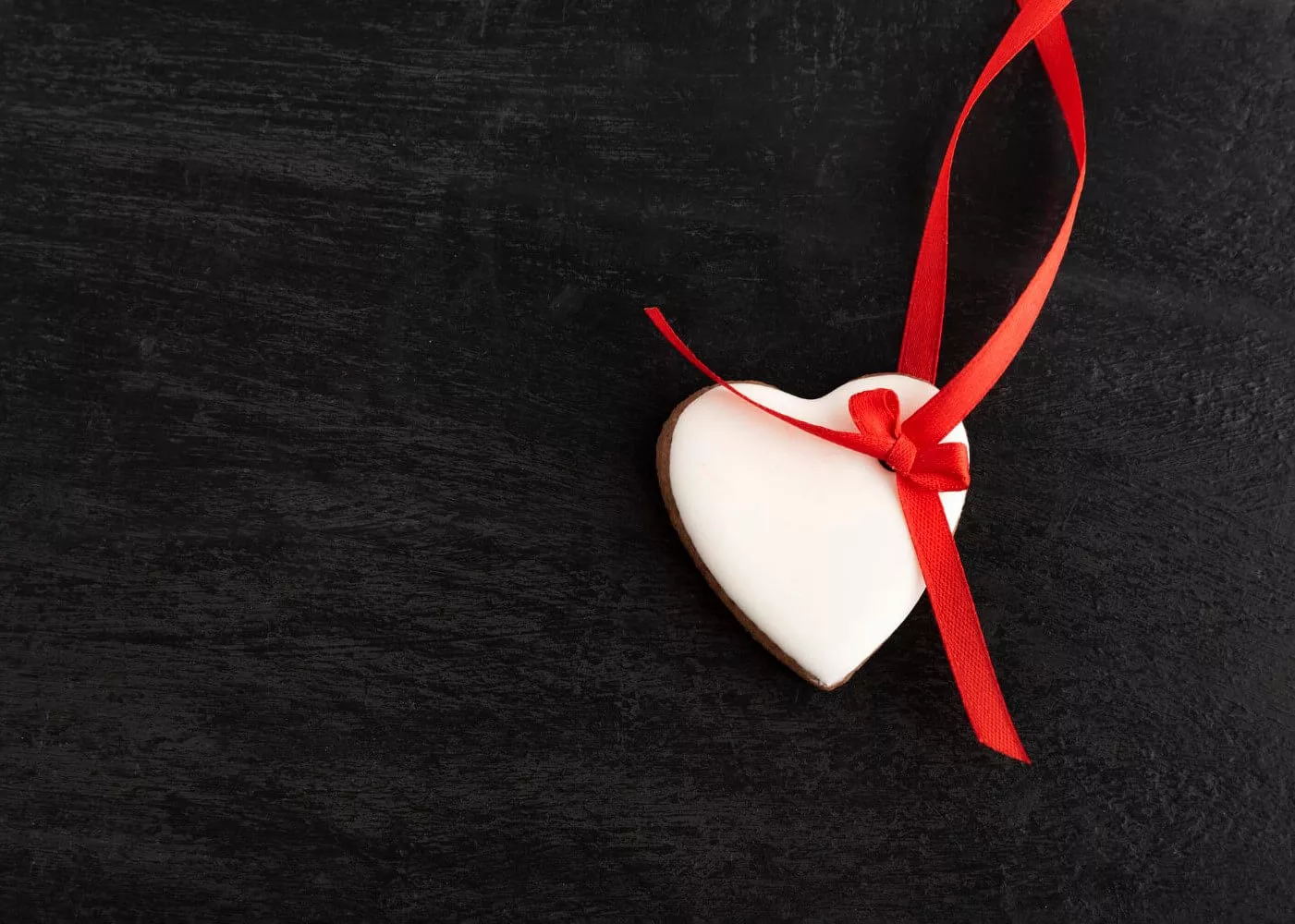 heart-shaped-cookies-with-icing-red-ribbon-black-background-copy-spase