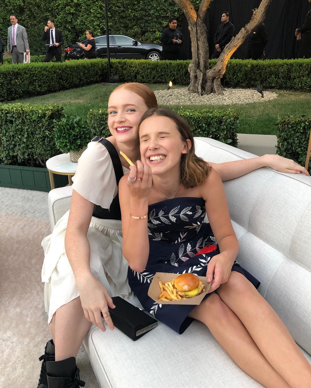 Millie Bobby Brown and Sadie Sink enjoying fries and burger.