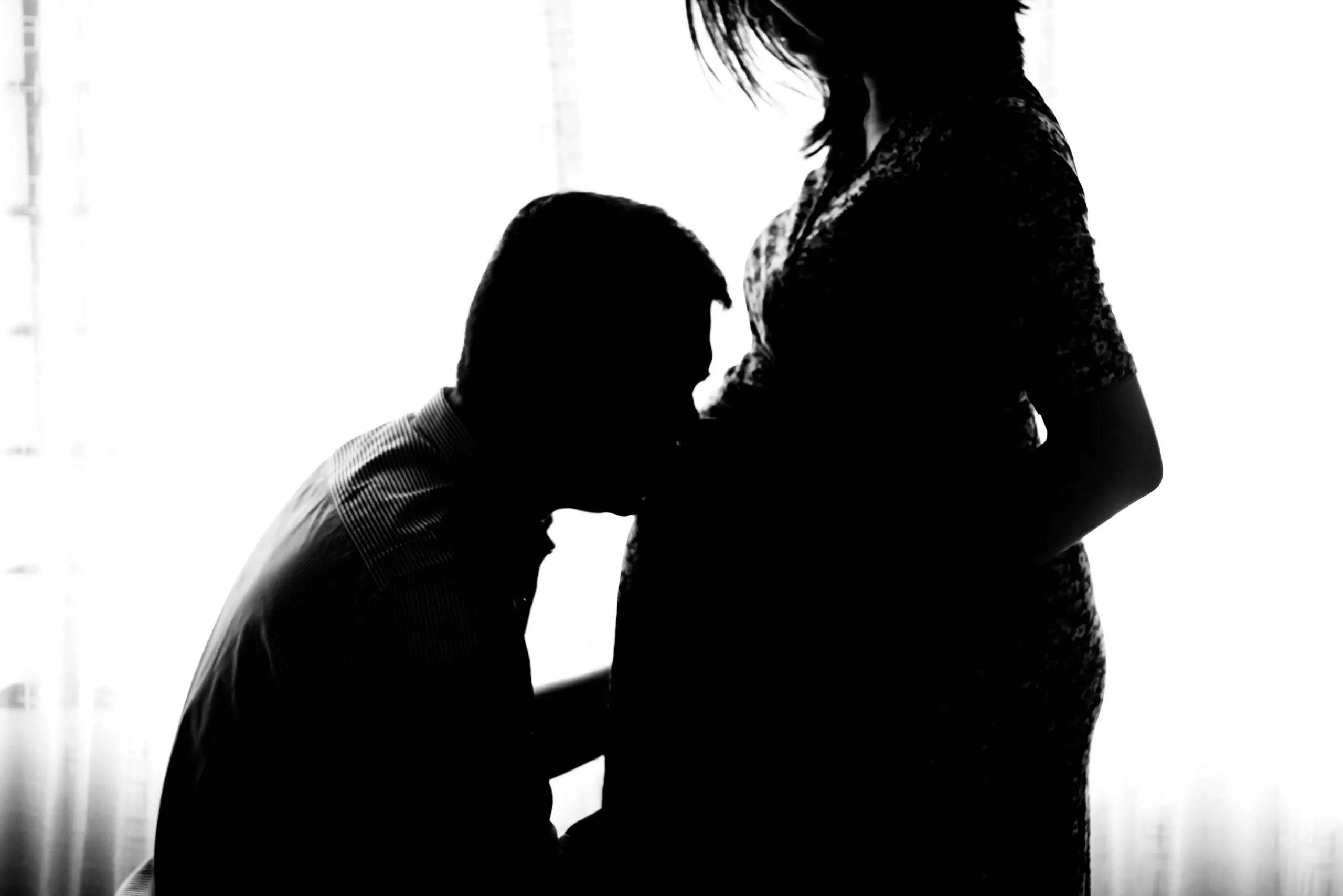 husband kissing pregnant wife