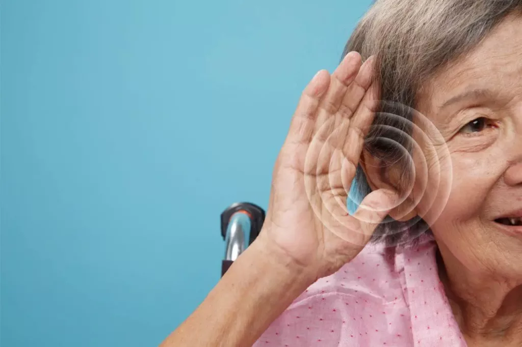 An old woman listening through hearing aids. 