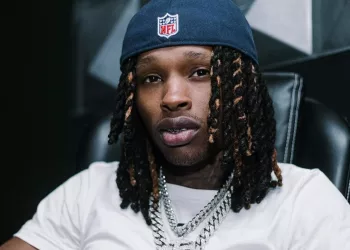 King Von wearing white tee and a cap.