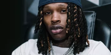 King Von wearing white tee and a cap.