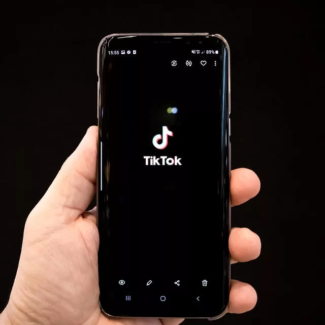 man holding phone and opened tiktok