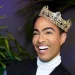 Pollito Tropical wearing a crown and black coat.