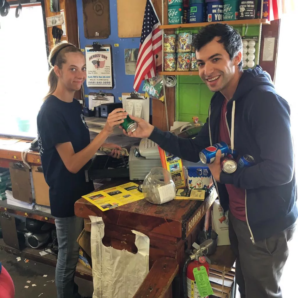 Nathan buying cold drink can from a store.