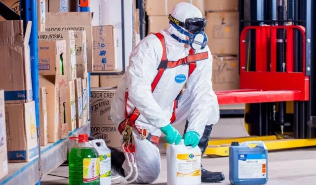 A man handling chemical and hazardous materials wearing safety suits.