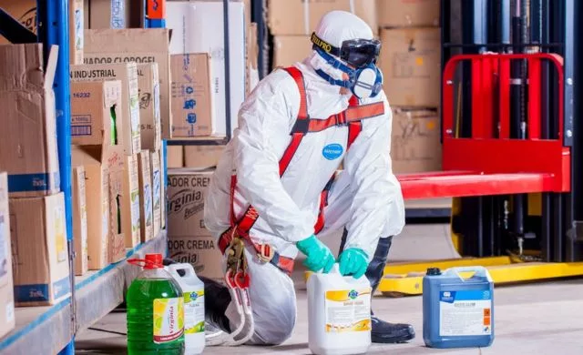 A man handling chemical and hazardous materials wearing safety suits.