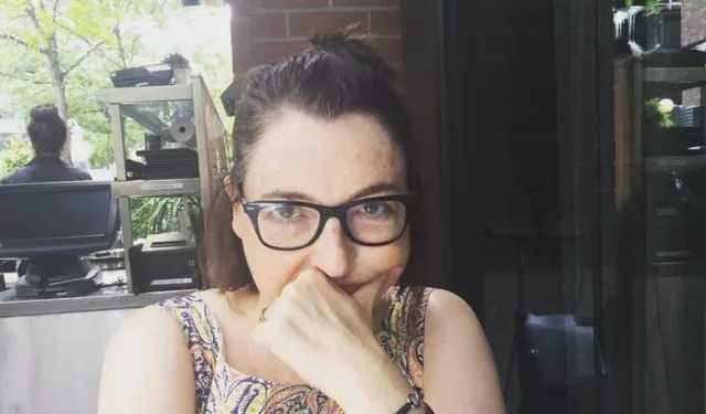 Mary Jolivet sitting in a restaurant and wearing black spectacles.