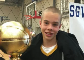 Jasper Breckenridge Johnson holding his trophy after his basketball match.