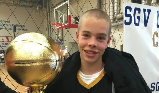 Jasper Breckenridge Johnson holding his trophy after his basketball match.