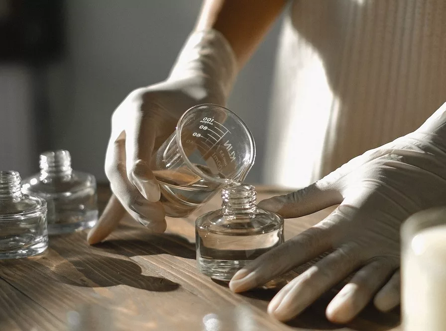 Crop black woman making aromatic liquid incense