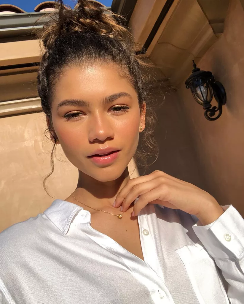 Zendaya taking selfie wearing a white shirt.