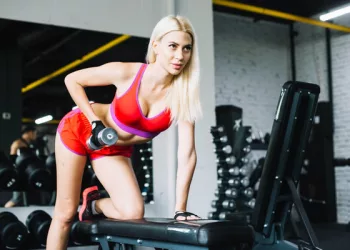 blonde-woman-lifting-dumbbell in gym