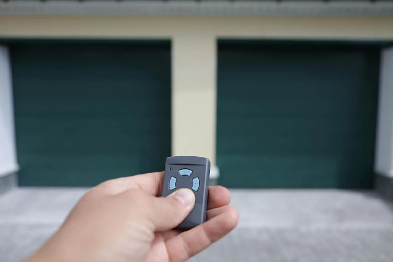 man-holds-his-hand-remote-control-that-opens-garage-door
