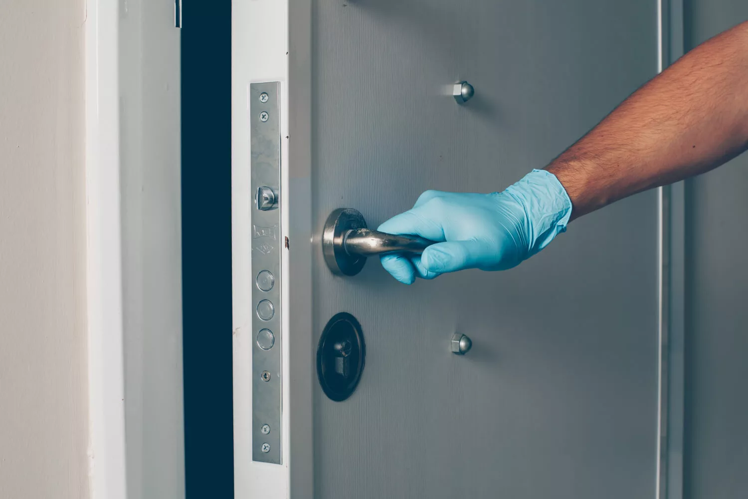 portrait-man-room-opening-door-with-hands-gloves