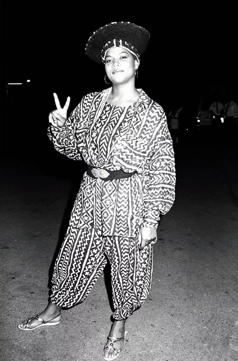 An old picture of Queen Latifah. She is wearing a tiger print jumpsuit with black belt.