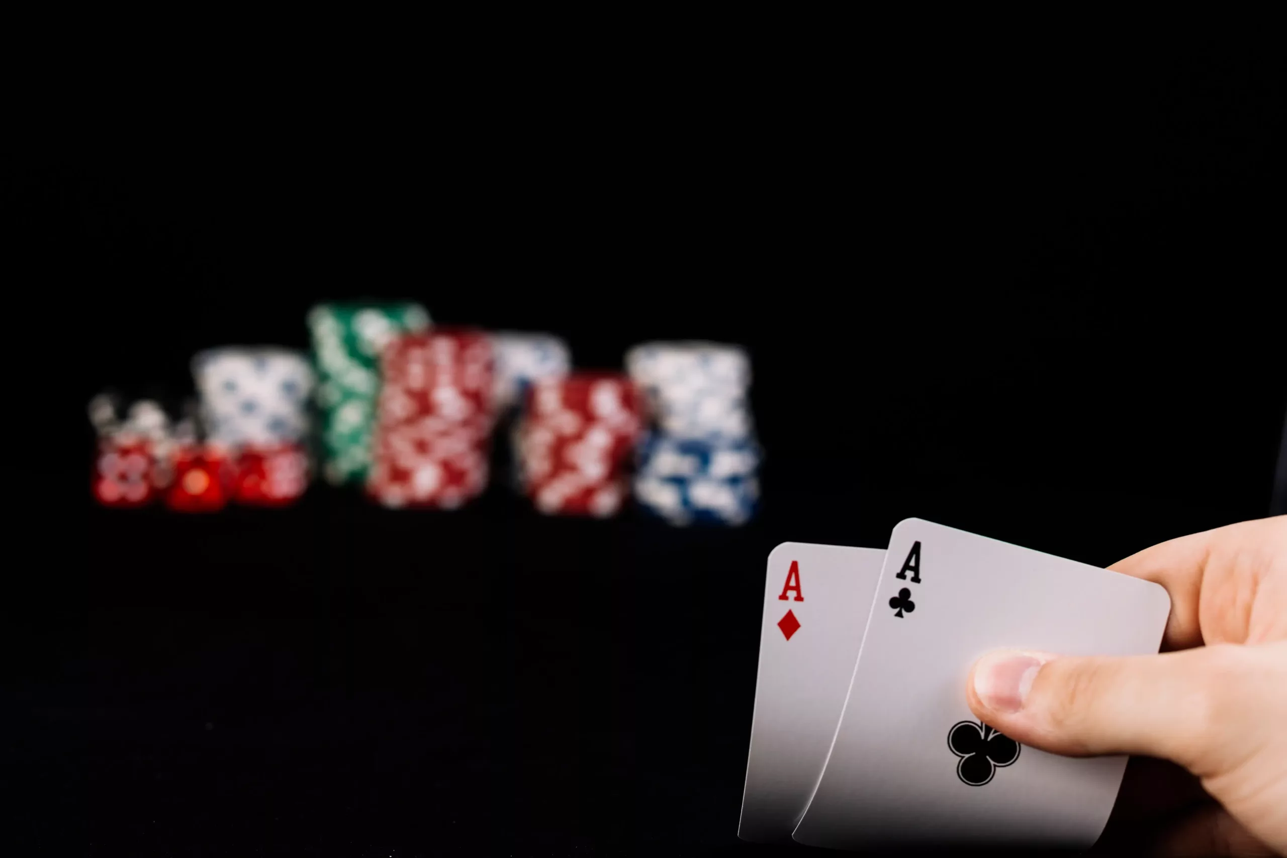 close-up-player-s-hand-holding-two-aces-playing-cards 