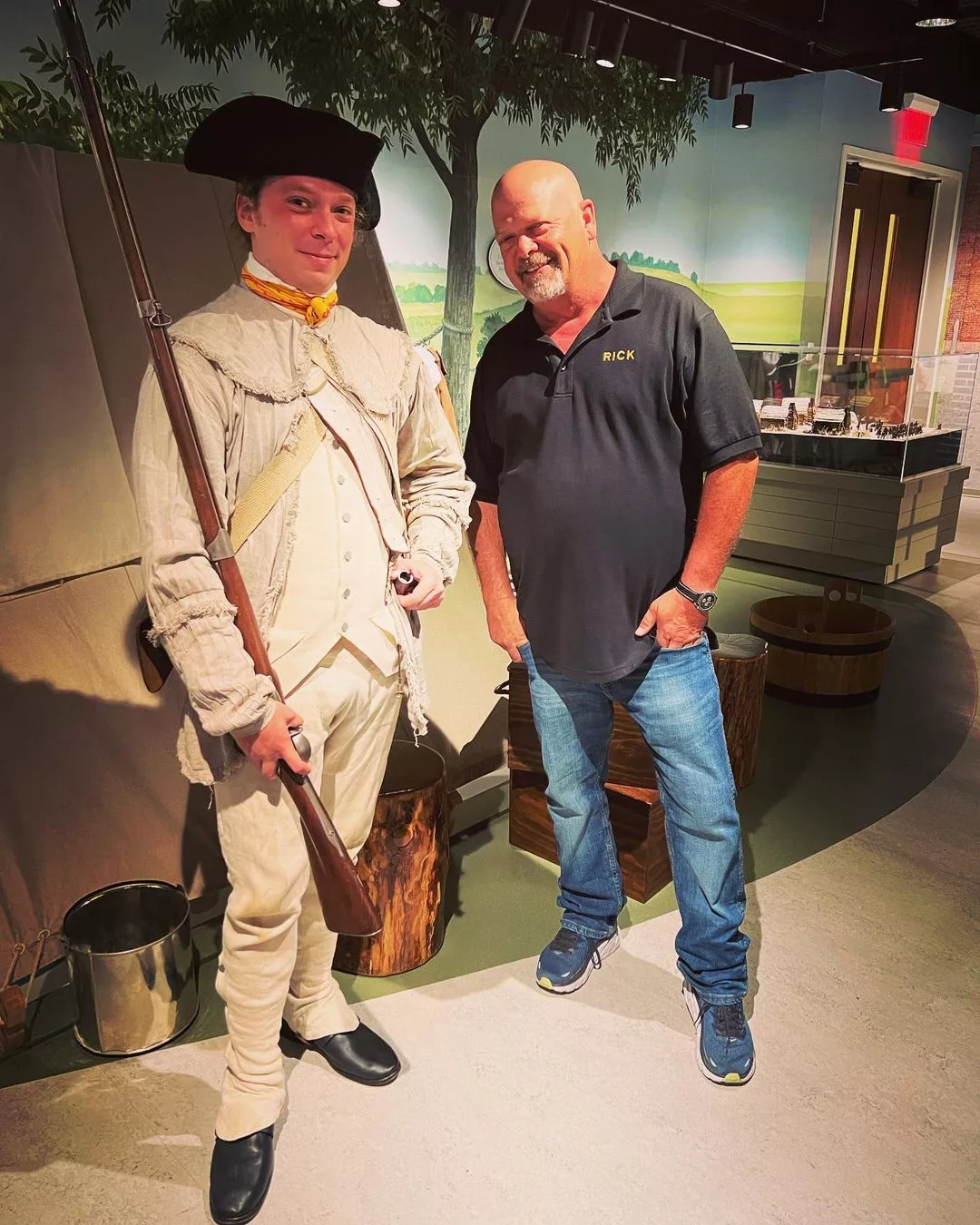 Rick Harrison posing at a museum with a statue. 