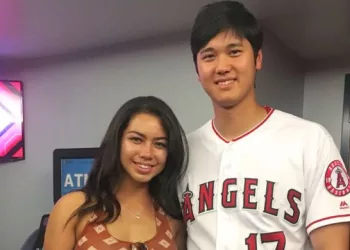 Kamalani Dung and Shohei Ohtani posing together for a picture. Dung is wearing a brown colred top and Ohtani is wearing his Angels jersey from game.