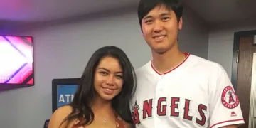 Kamalani Dung and Shohei Ohtani posing together for a picture. Dung is wearing a brown colred top and Ohtani is wearing his Angels jersey from game.