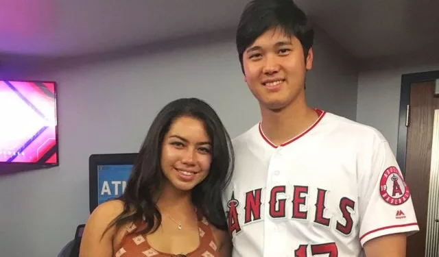 Kamalani Dung and Shohei Ohtani posing together for a picture. Dung is wearing a brown colred top and Ohtani is wearing his Angels jersey from game.