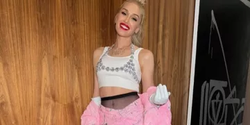 Gwen Stefani wearing a white top and light pink skirt.