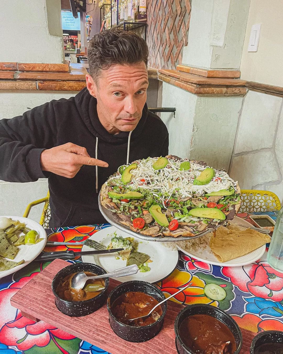 Seacrest showing a plate of taco.