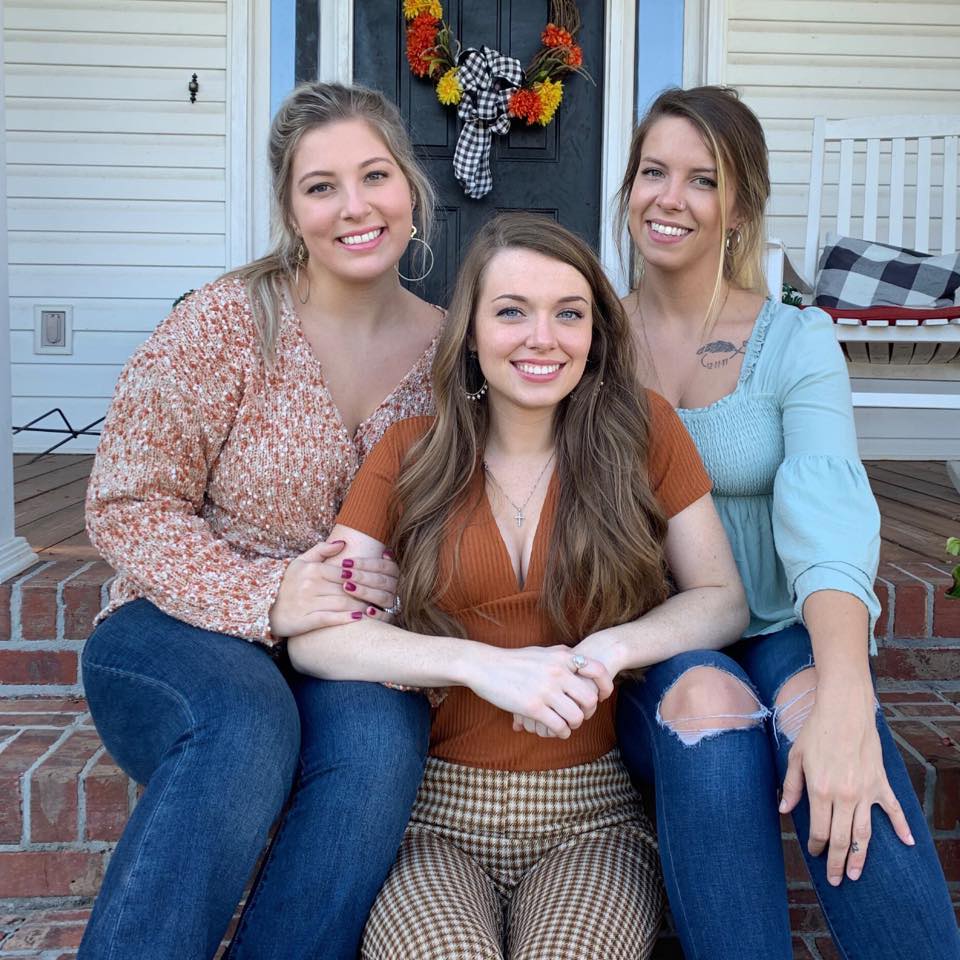 Taelyn posing with some of her cousins. She and her cousins are sitting on the porch stairs.