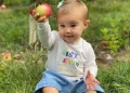 Wyatt Kelce holding an apple in her hand.
