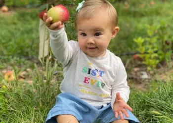 Wyatt Kelce holding an apple in her hand.