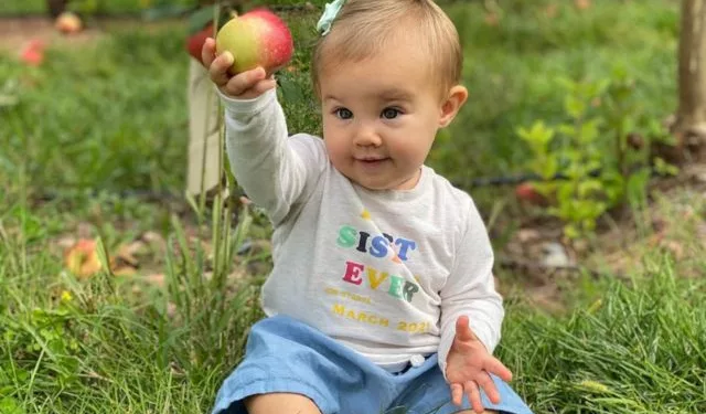 Wyatt Kelce holding an apple in her hand.