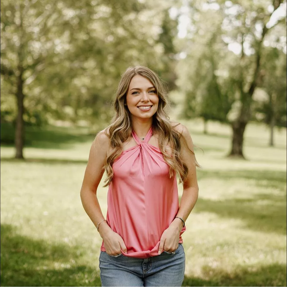 Taelyn wearing a pink colored top paired with blue jeans.