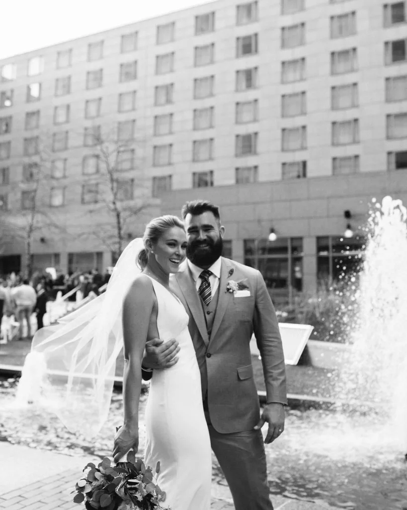 Jason & Kylie on their wedding day. Jason is wearing a grey coat and Kylie is wearing white bridal dress.