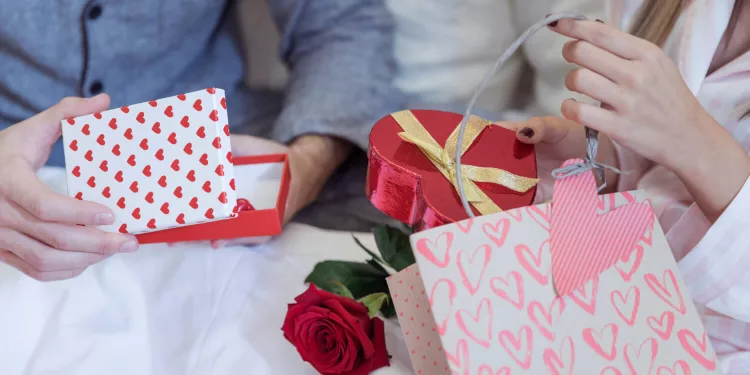 couple-pajamas-sitting-bed-with-gifts