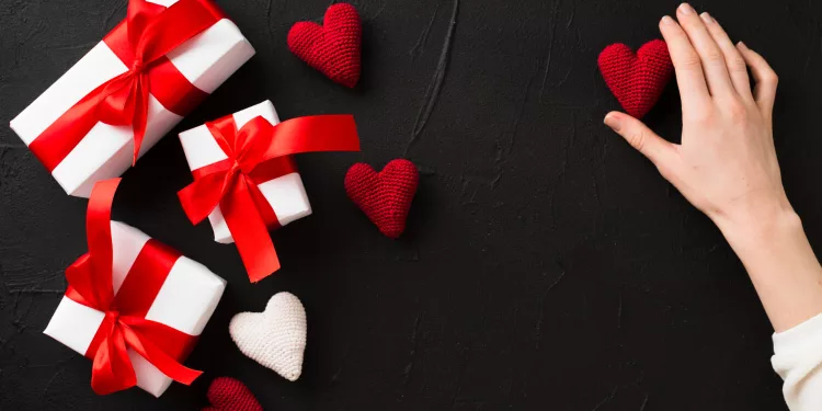 crop-hand-touching-heart-near-presents